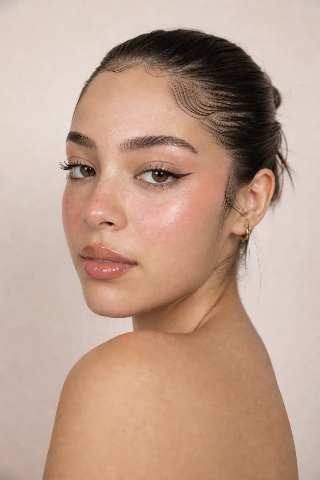 Model with fair olive skin wearing soft rose blush high on the cheek and wispy doe lashes